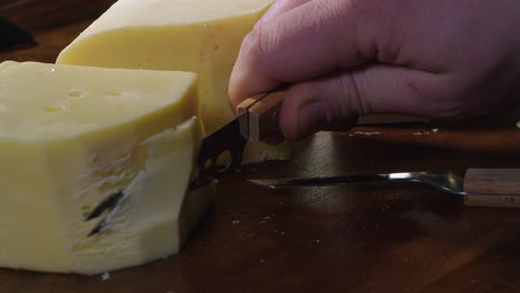 swiss, gouda and brie cheese on board: block sliced with small knife