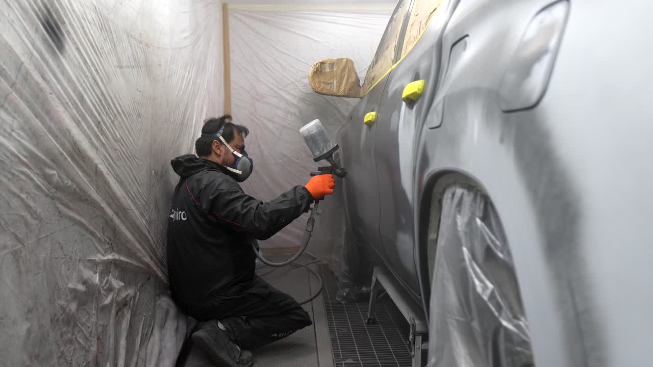 Man Spray Painting Car in Auto Body Shop