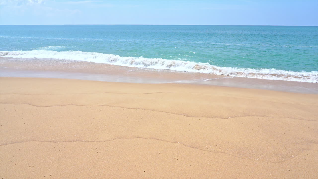 해안 슬로모에서 파도가 굴러가는 한적한 모래 햇살 가득한 해변
