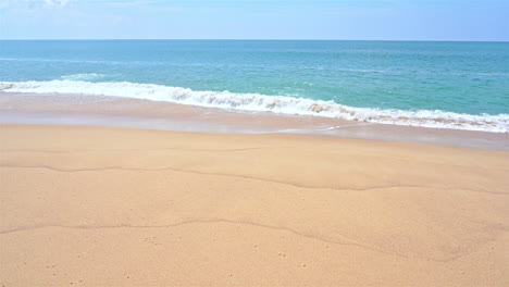 secluded sandy sunny beach with waves rolling on the shore slomo