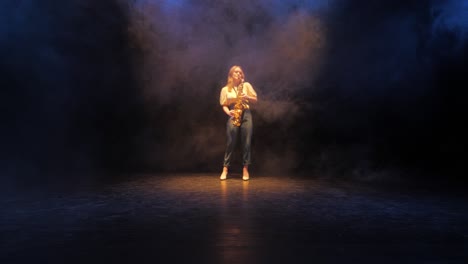 young woman playing saxophone under spotlights on stage, wide view