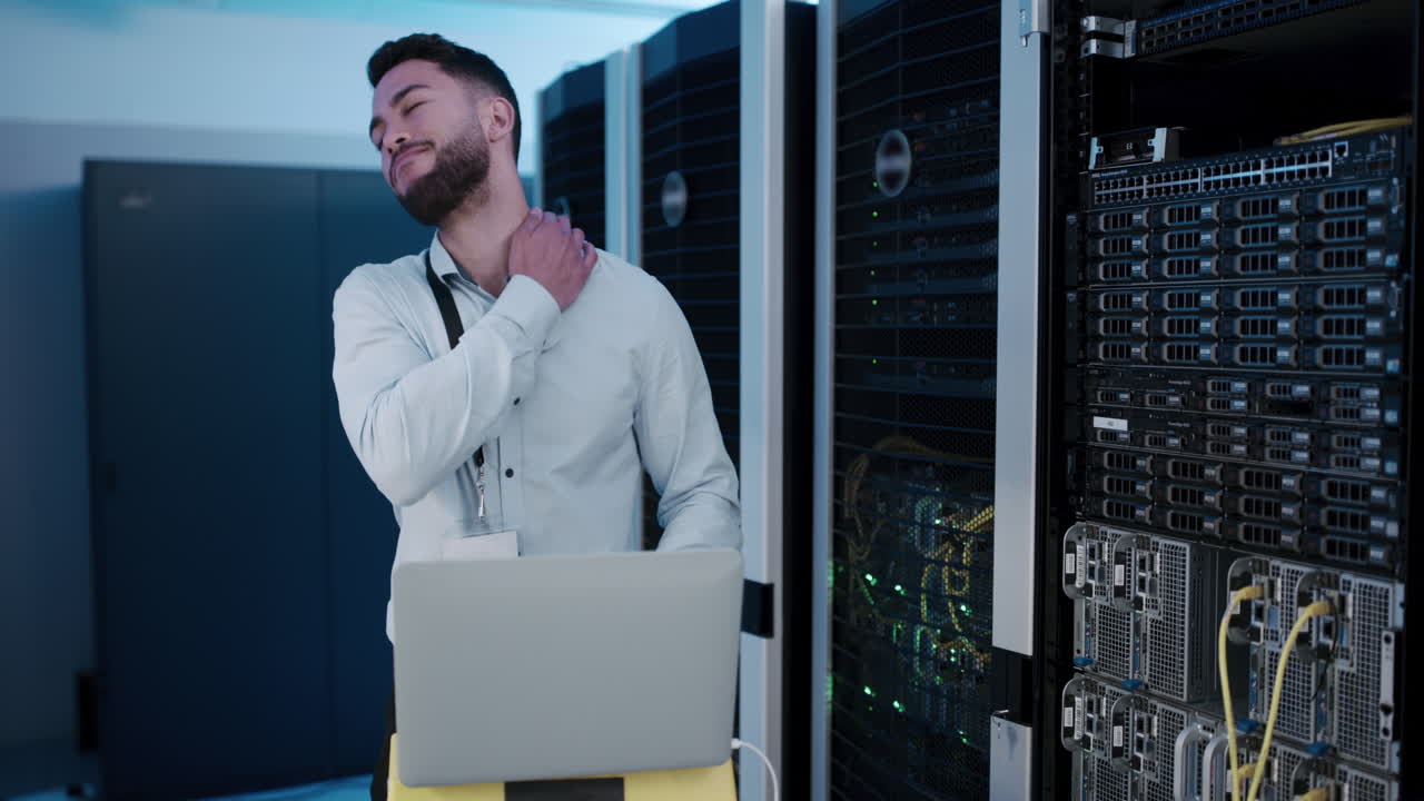 técnico con dolor de cuello en la sala de servidores