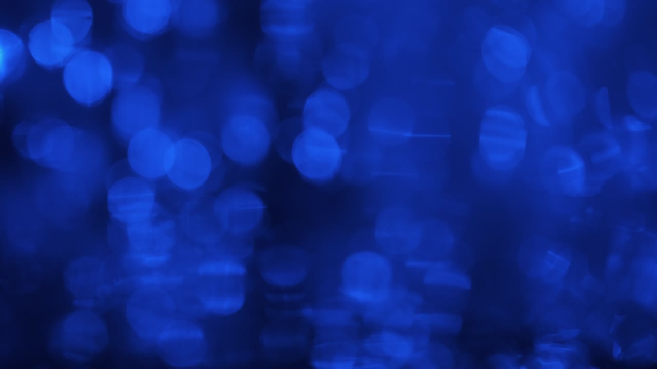 gota cayendo en el agua con bokeh azul reflejado. olas y ondas en la superficie del agua