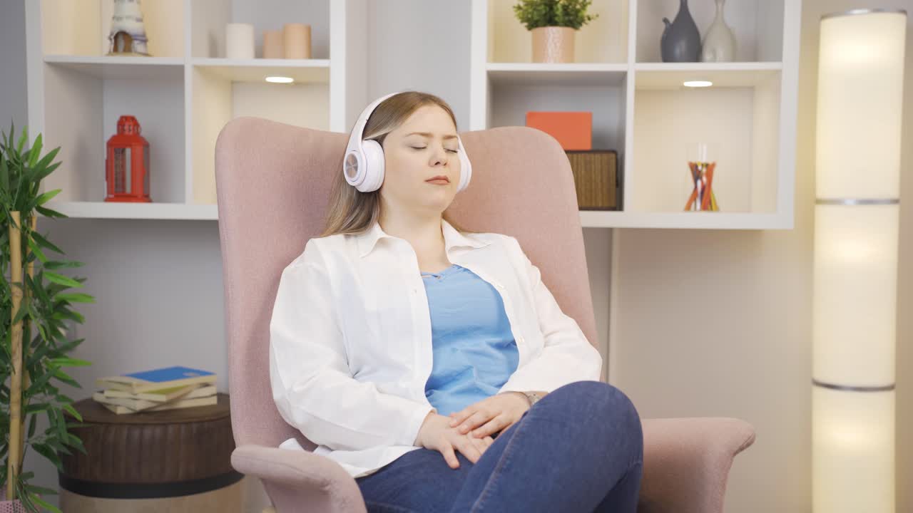 헤드폰으로 음악을 듣는 젊은 여성은 불행하고 슬프다.