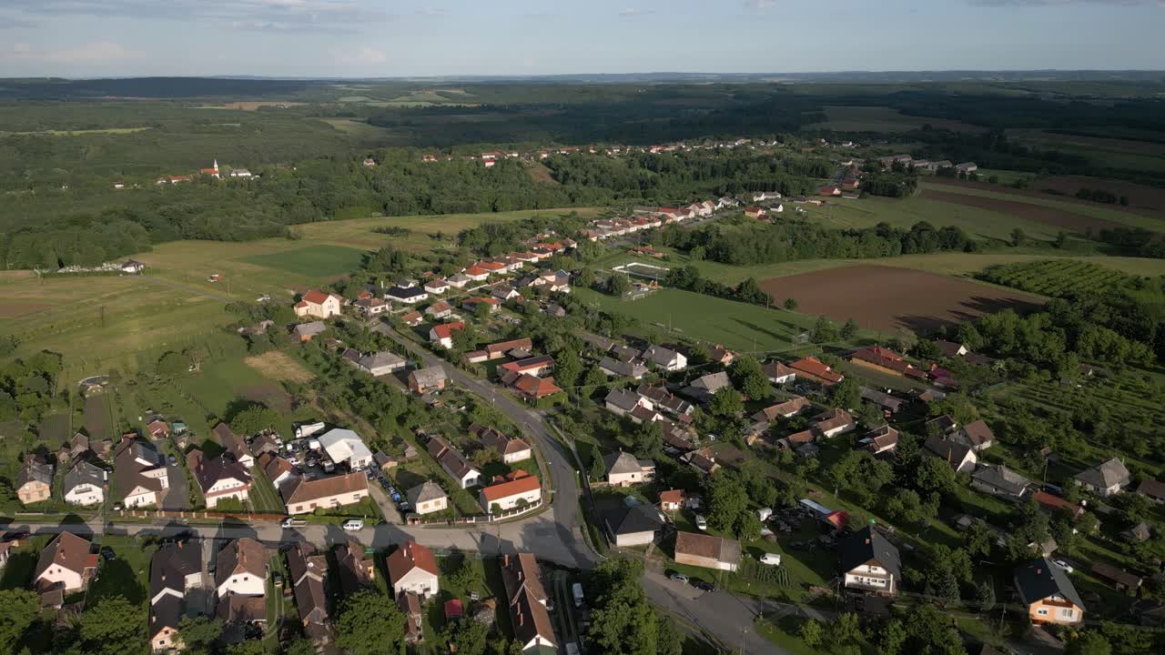 Aerial view of a village surrounded by fields and greenery