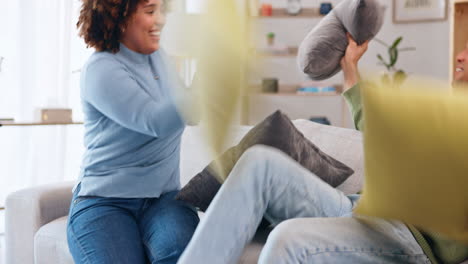 almohada, pelea y pareja feliz en la sala de estar