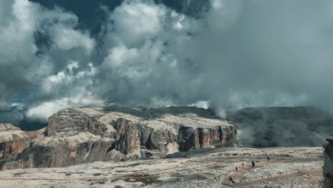 dramatic timelapse capturing rolling clouds drifting over rocky pordoi pass landscape in italian dolomites, revealing dramatic mountain scenery and atmospheric cloudscape