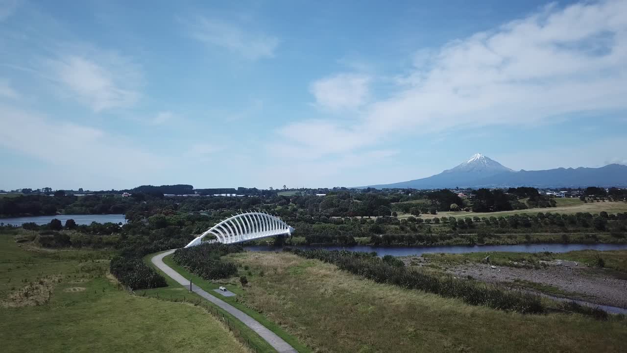 Aerial drone shot, descending and closer to the bride, view of the landmark bridge [Te Rewa Rewa Bridge] and the Mt. Taranaki as background in New Plymouth, New Zealand