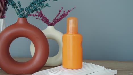orange sunscreen bottle with decorative vases