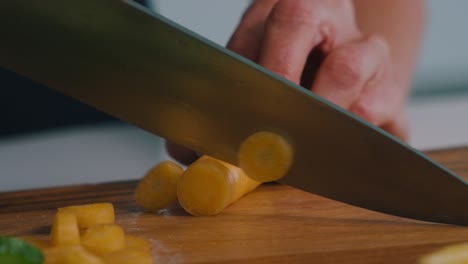 una persona cortando verduras zanahorias en una cocina en un día soleado