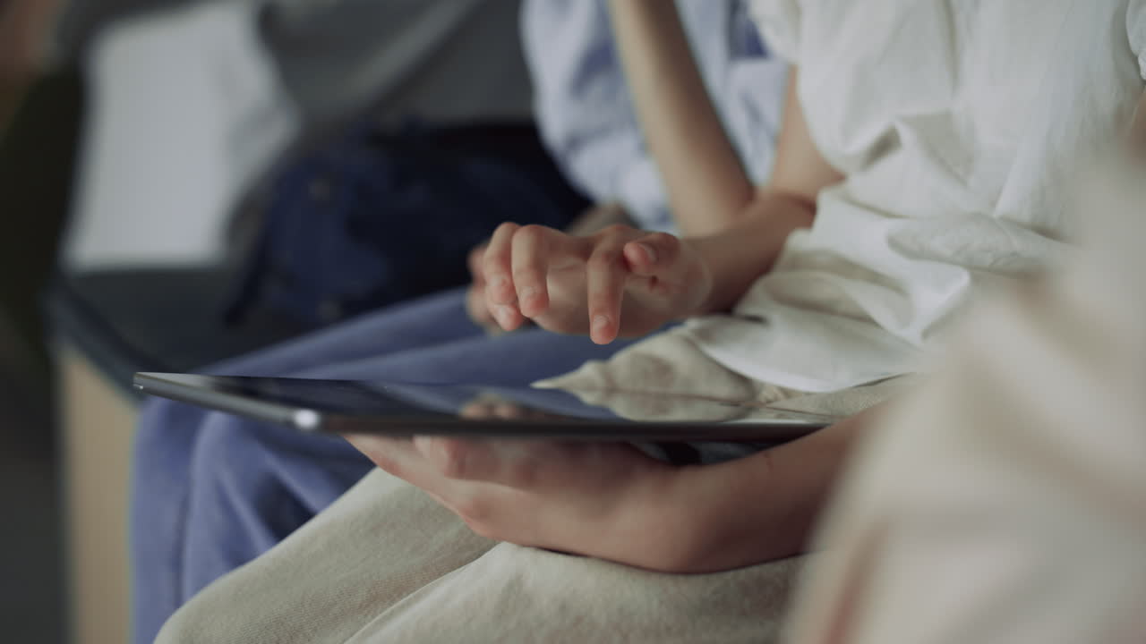 Child hand tapping tablet computer at break close up. Pupils surfing internet.