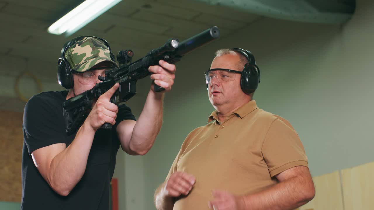 un hombre aprende a disparar un rifle en el campo de tiro. el instructor muestra al aprendiz la posición correcta de tiro
