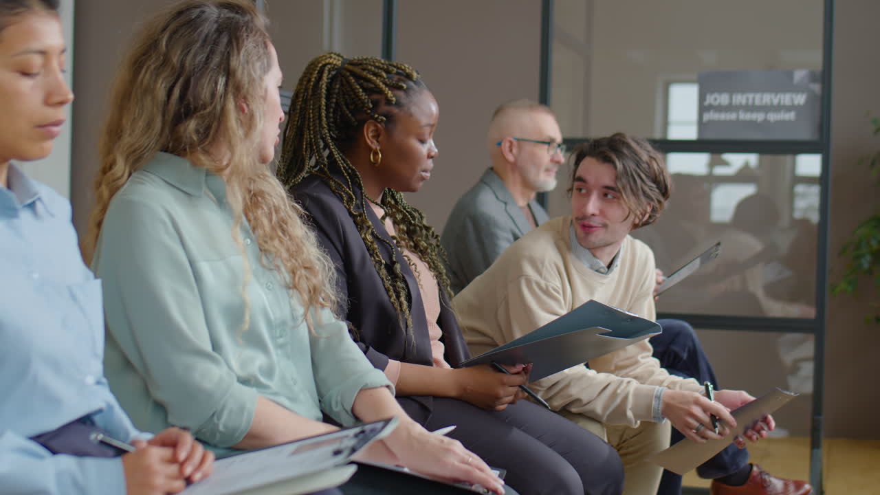 Multiethnic Job Candidates Sitting in Line and Chatting