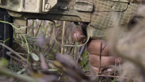 close-up-of-gunman-hand-pulling-rifle-trigger-in-war-zone