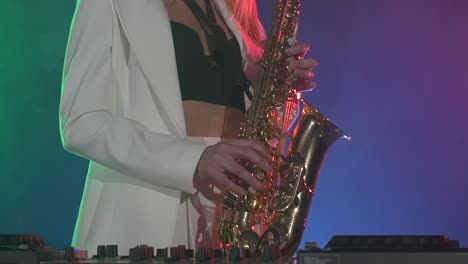 woman playing saxophone on a dj stage