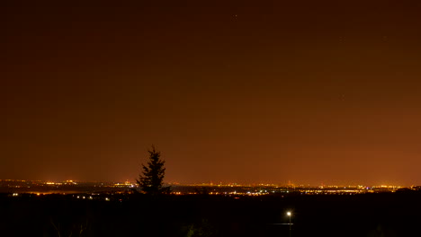 Time-lapse-starry-night-sky-over-city-in-distance