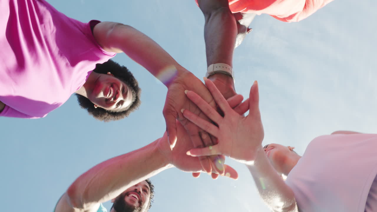 Diverse Team Huddling Hands and Cheering Under Blue Sky