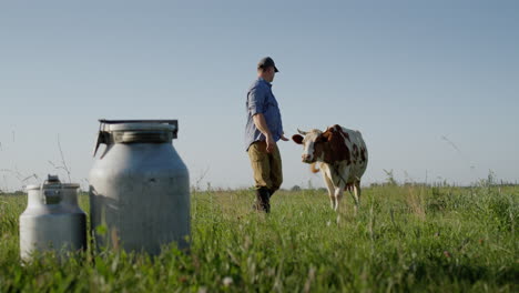 Proud-farmer-stands-in-a-pasture-where-his-cows-graze-1