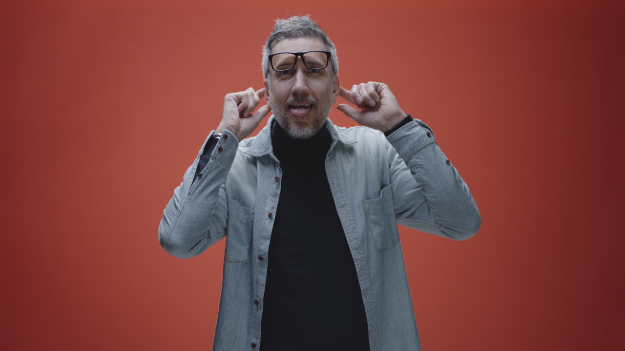 Man covering ears in a studio setting