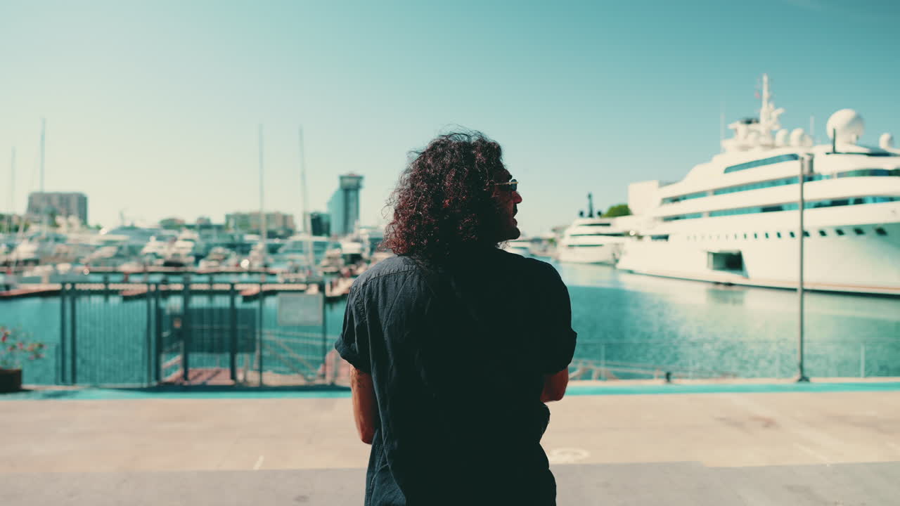 Man looking at yachts in a marina