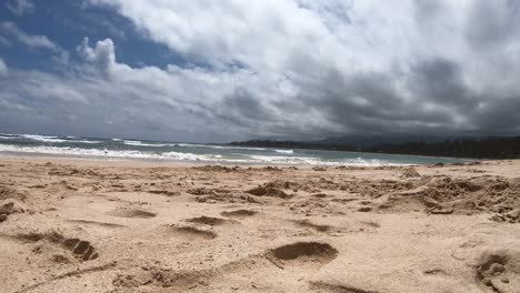 Lapso-De-Tiempo-Desde-La-Vista-Del-Suelo-De-La-Arena-Y-La-Playa-Y-Las-Nubes-Que-Se-Mueven-Rápidamente-En-Una-Playa-De-La-Costa-Norte-En-Oahu-Hawaii,-Que-Está-Desierta-En-Este-Momento