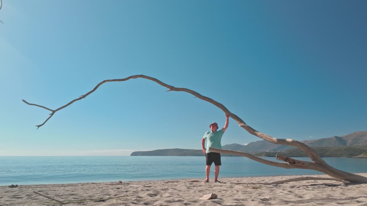 Senior Man enjoys solitude on peaceful Greek beach in morning sun