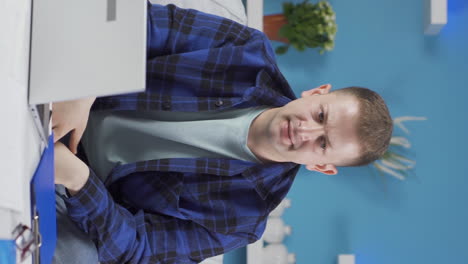 vertical video of home office worker man looking at the file angrily.