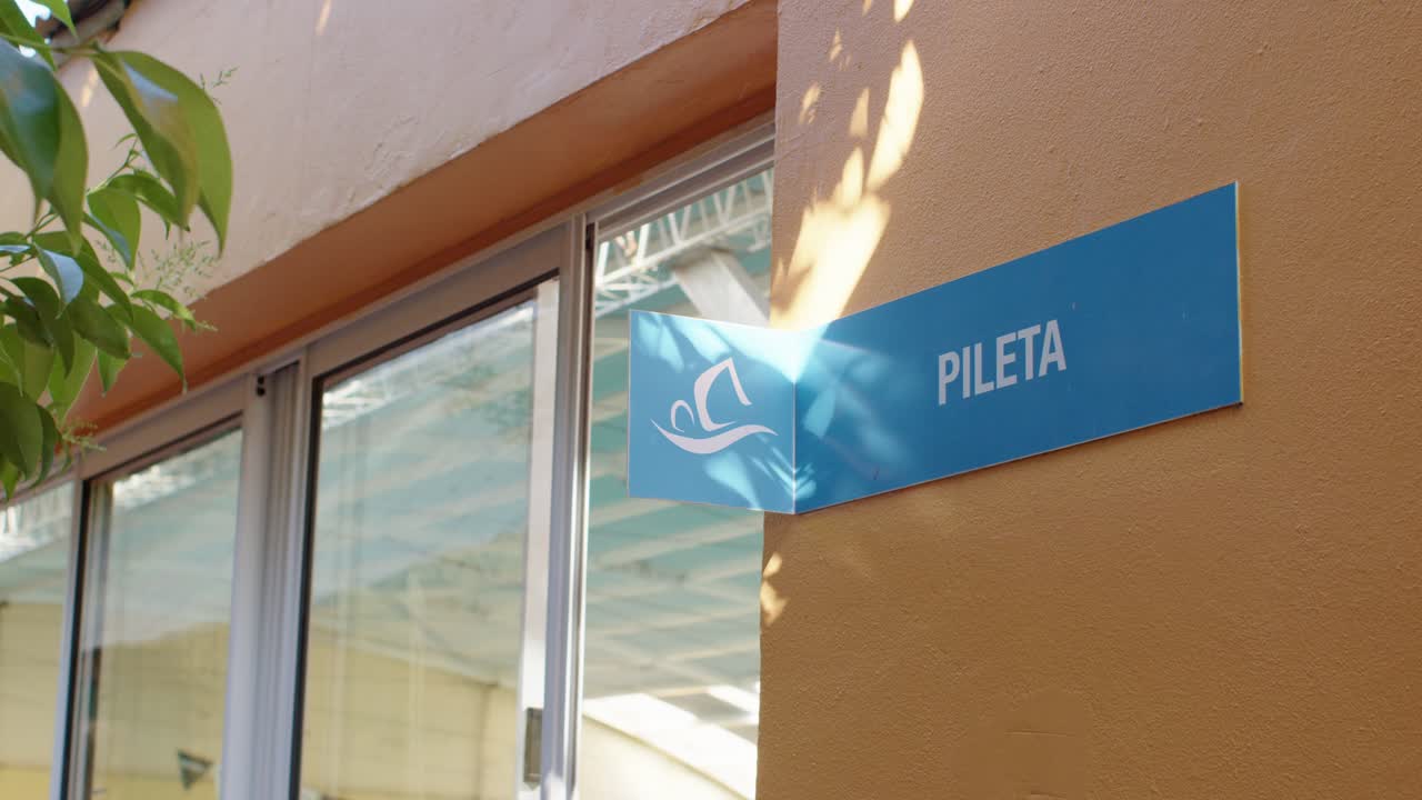 señalización clara que indica el camino a la zona de la piscina, guiando a las personas a su ubicación con facilidad durante el día