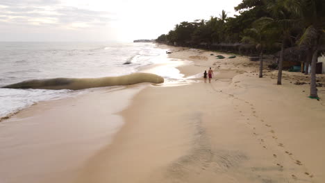 Forward-view-of-a-couple-walking-on-a-disappearing-beach-with-geo-tube-in-evidence-Vietnam