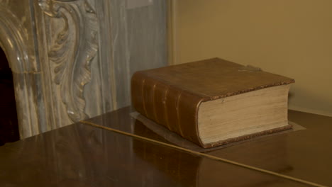 pan past large, old book lying on a antique desk