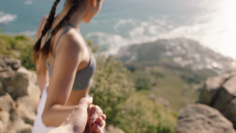 couple holding hands woman leading boyfriend climbing mountain hiking with girl friend enjoying outdoor travel adventure pov