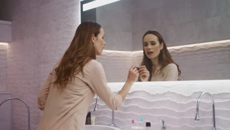 business woman drawing heart with lipstick in the mirror