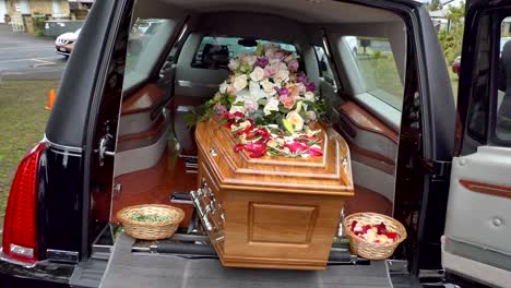 closeup shot of a funeral casket in a hearse or chapel or burial at cemetery