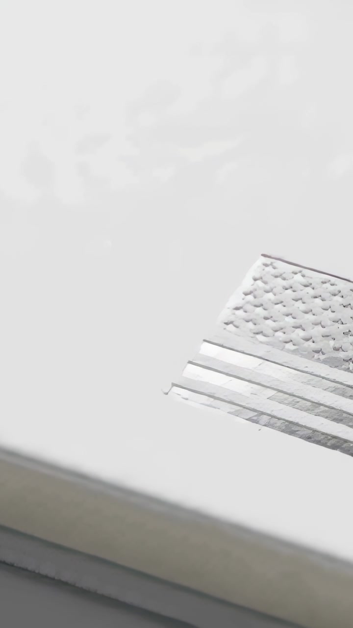 Vertical video: Start cam panning revealing foil flag on white box showing layered edge, copy space