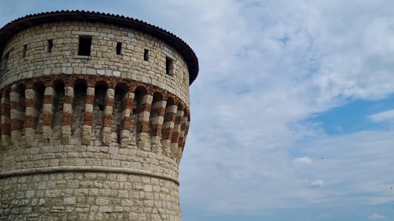 Ancient Stone Tower with Birds Flying in the Sky