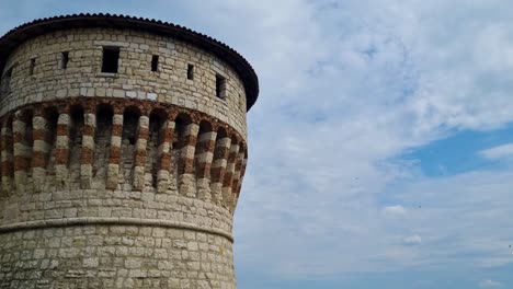 ancient stone tower with birds flying in the sky