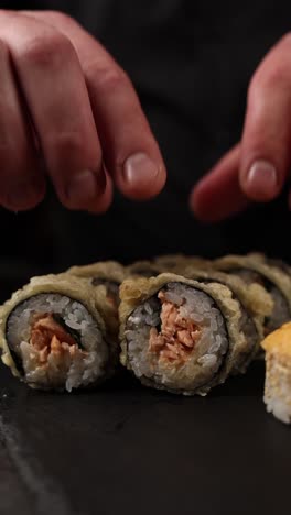 chef preparing tempura salmon sushi rolls