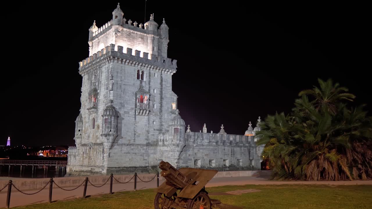Iconic Bel&eacute;m Tower from the surrounding park at night with a historical cannon in the foreground in Lisbon, Portugal