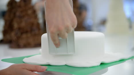 Nahaufnahme-Einer-Frau-In-Einer-Bäckerei,-Die-Kuchen-Mit-Zuckerguss-Dekoriert