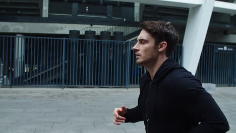 deportista de primer plano corriendo en entrenamiento cardiovascular al aire libre. atleta enfocado corriendo