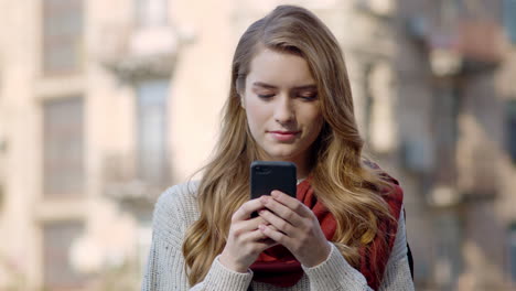 Beautiful-woman-using-phone-outdoors.-Pretty-girl-looking-phone-screen-on-street