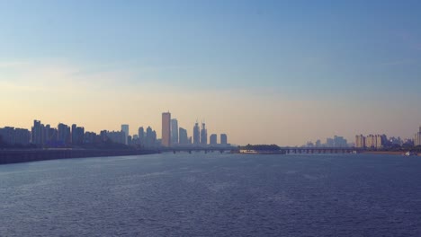 Puesta-De-Sol-En-Seúl-Vista-Desde-El-Puente-Dongjak,-Aquí-Puedes-Ver-Uno-De-Los-Aspectos-Más-Destacados-De-La-Ciudad:-La-Torre-63,-Que-Es-Uno-De-Los-Edificios-Más-Altos-De-La-Ciudad