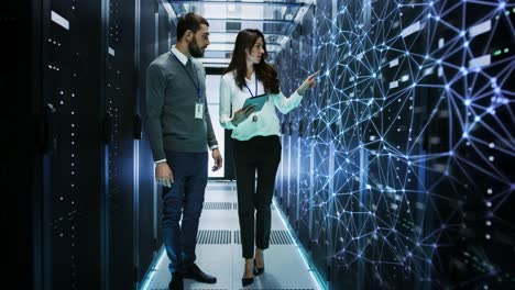 looped cinemagraph: male and female it engineers standing in the working data center with server racks covered in conceptual graphics of digitalization showing data cells.