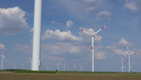 view on several windmills, wind generators, turbines, producing renewable clean energy by converting kinetic energy