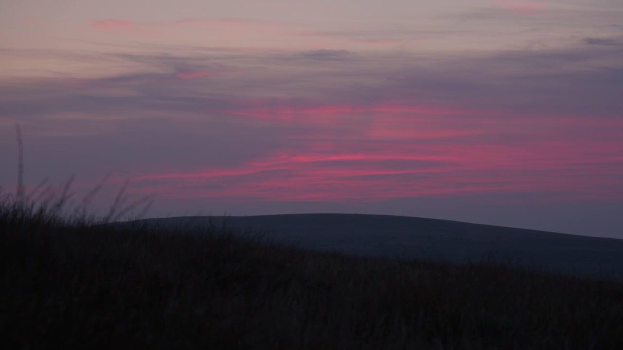 Cielo colorato al tramonto sulla campagna del Parco Nazionale di Dartmoor nel Devon, Inghilterra sud-occidentale. Inquadratura fissa.