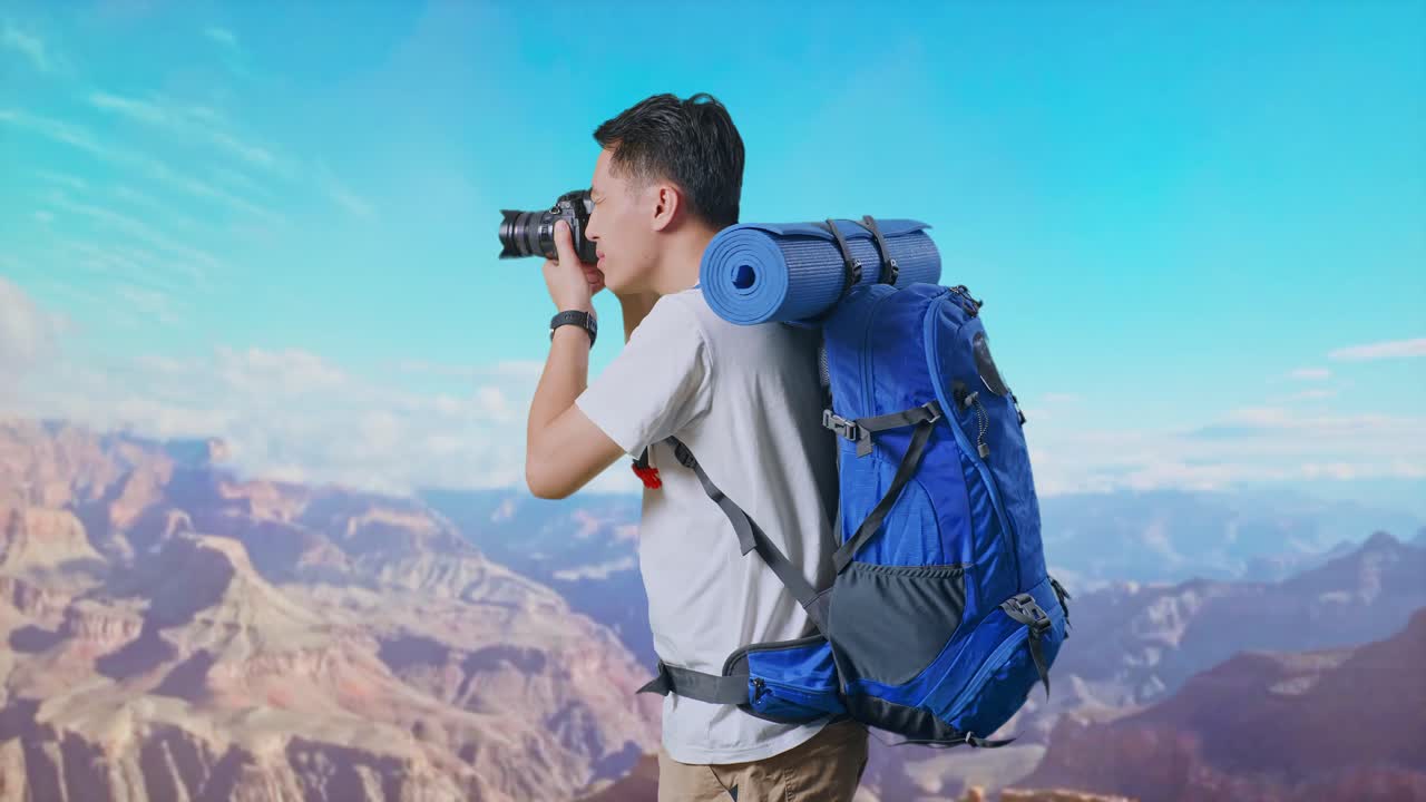 Side View Of Asian Male Hiker With Mountaineering Backpack Using A Camera Taking Picture While Traveling At The Top Of Mountain