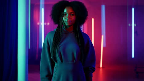 young woman with afro hair in a neon lit room
