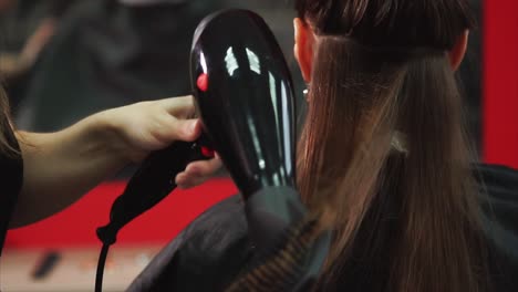 hair salon: styling a woman's hair with a hair dryer and brush