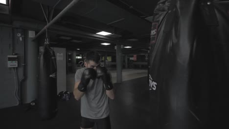 young athletic man doing exercise at the gym with a punching bag