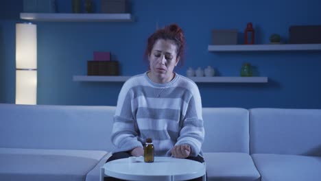 la mujer que toma las pastillas en la mesa con las manos temblando. suicidio.
